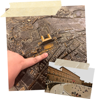 A photo of me pointing to where my apartment was on a raised map of Palazzo Pitti. Taped to the corner is an image of the Pitti Palace.